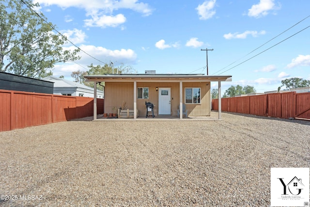 rear view of house featuring a fenced backyard