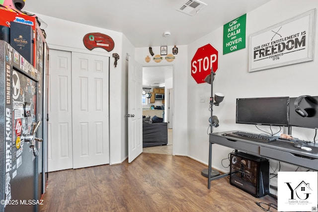 home office with visible vents, baseboards, and wood finished floors