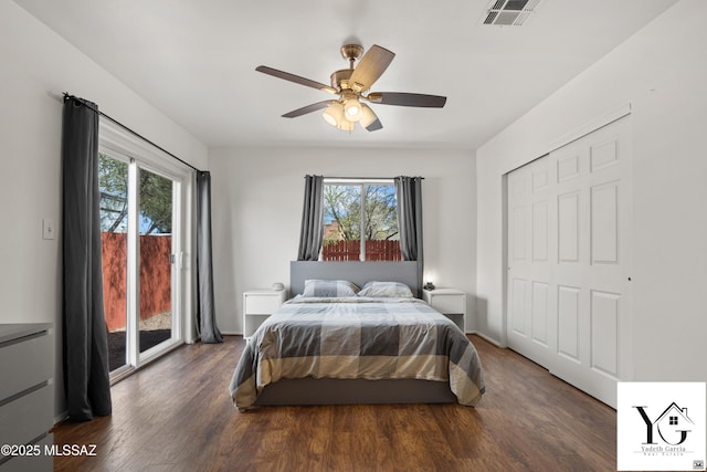 bedroom featuring access to exterior, wood finished floors, visible vents, and multiple windows