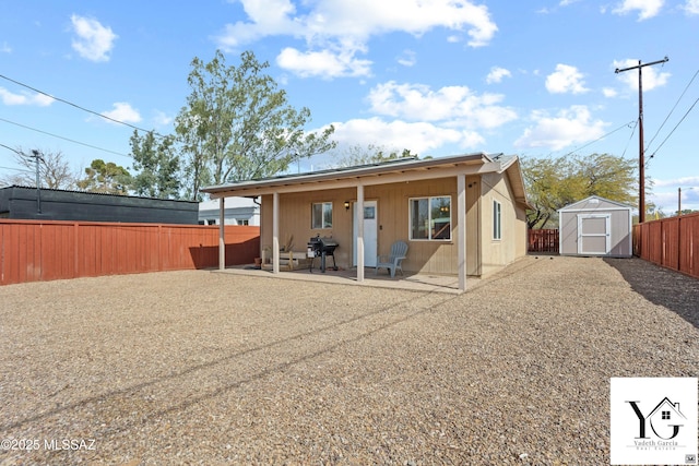 back of house with a storage unit, a patio area, a fenced backyard, and an outdoor structure