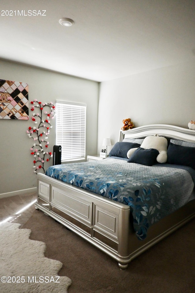 bedroom with dark carpet and baseboards