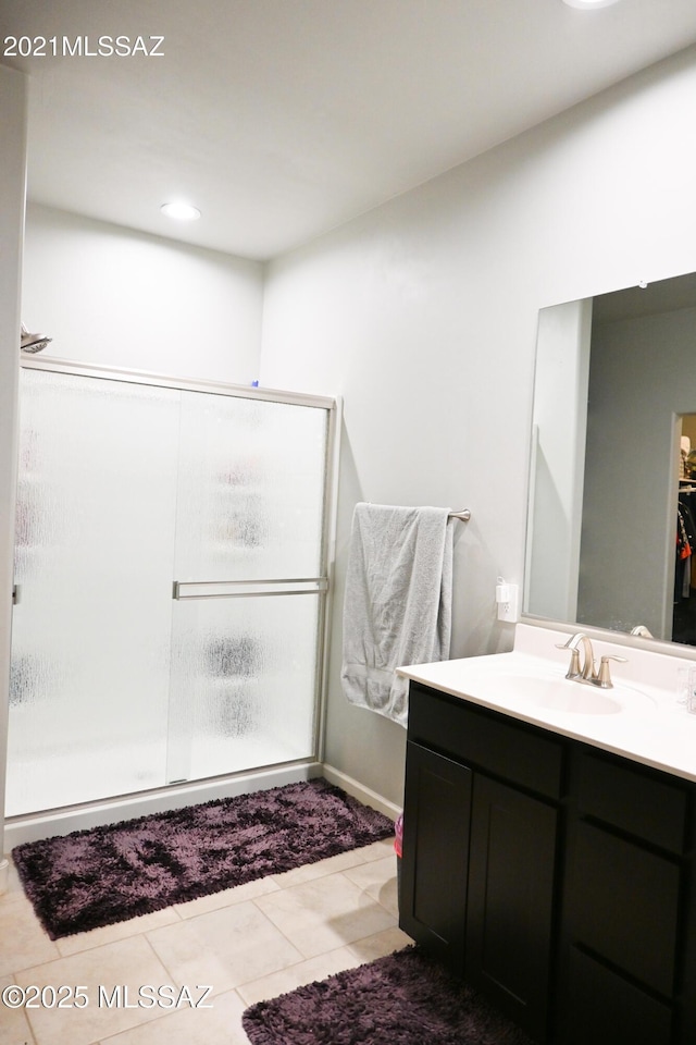 bathroom with a stall shower, tile patterned flooring, and vanity