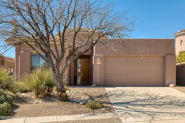 adobe home featuring an attached garage, driveway, and stucco siding