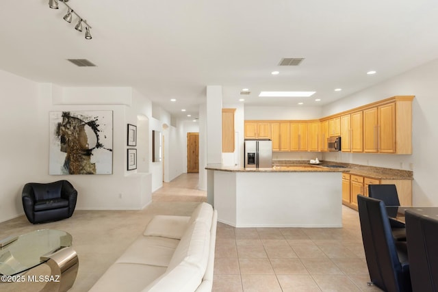 kitchen with a skylight, visible vents, open floor plan, stainless steel appliances, and recessed lighting