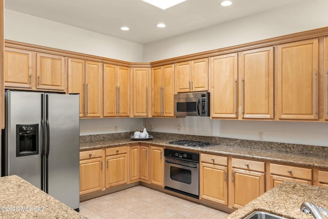 kitchen with stainless steel appliances, light stone counters, light tile patterned flooring, and recessed lighting