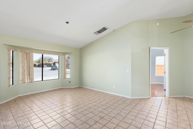 spare room featuring lofted ceiling, baseboards, visible vents, and light tile patterned flooring