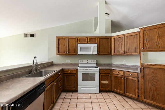 kitchen featuring lofted ceiling, white appliances, a sink, and brown cabinets