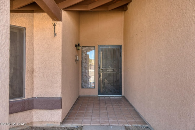 doorway to property featuring stucco siding