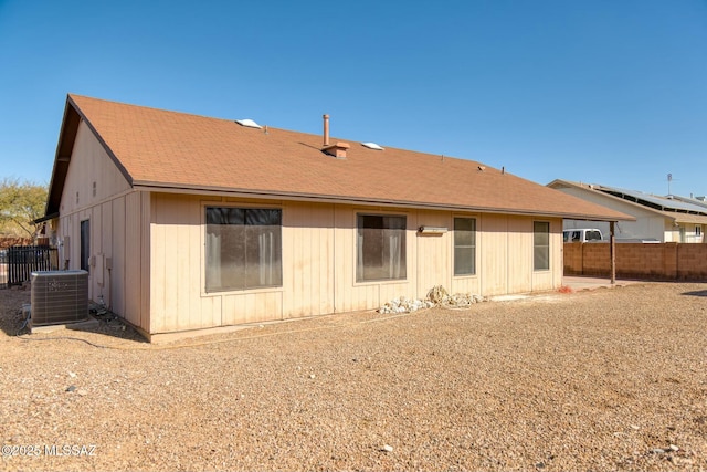 rear view of property with fence and central AC