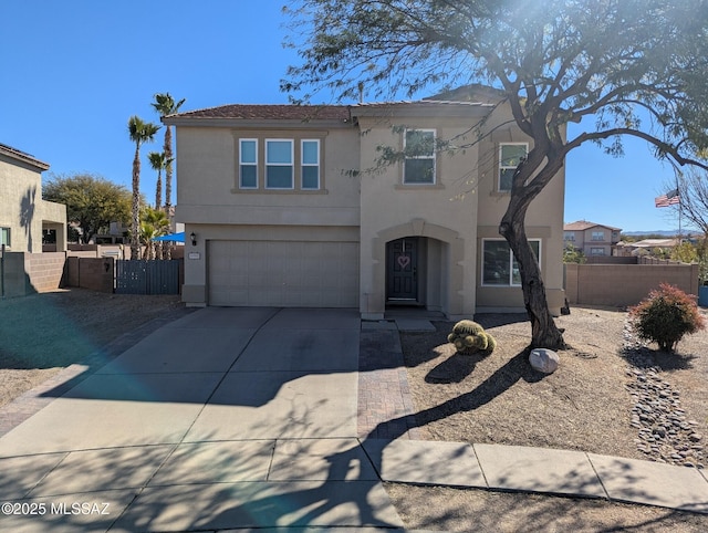 view of front of property featuring concrete driveway, fence, and stucco siding