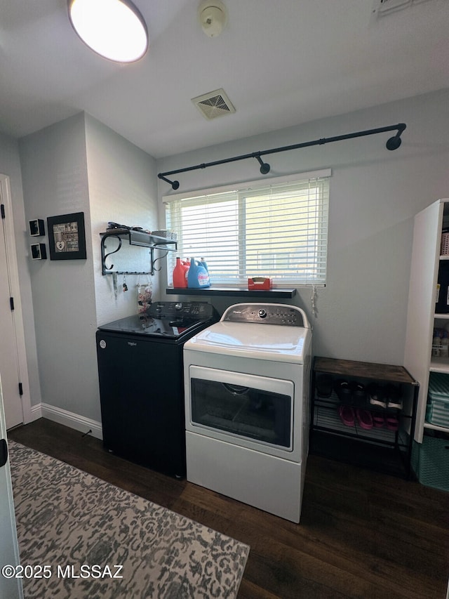 kitchen featuring dark wood-style floors, independent washer and dryer, visible vents, and baseboards