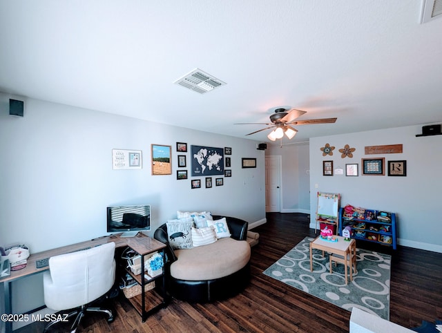 living area with ceiling fan, wood finished floors, visible vents, and baseboards