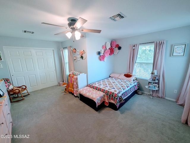 carpeted bedroom with a ceiling fan, a closet, and visible vents