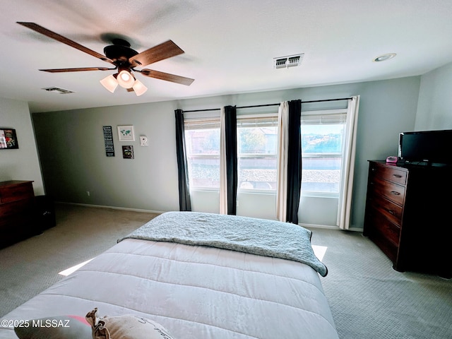 bedroom featuring ceiling fan, baseboards, visible vents, and light colored carpet