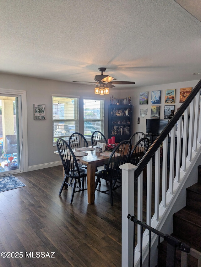 dining room with dark wood-style flooring, baseboards, stairway, and a textured ceiling