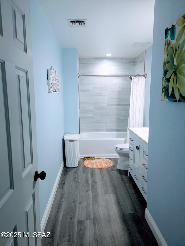 bathroom featuring visible vents, toilet, vanity, wood finished floors, and baseboards