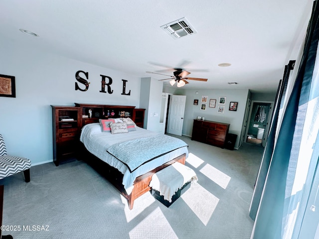 bedroom featuring a ceiling fan, visible vents, and light carpet