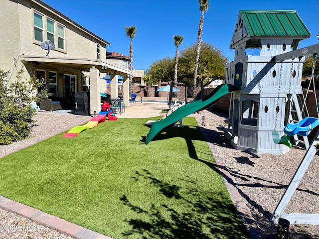 view of playground featuring a patio and a yard