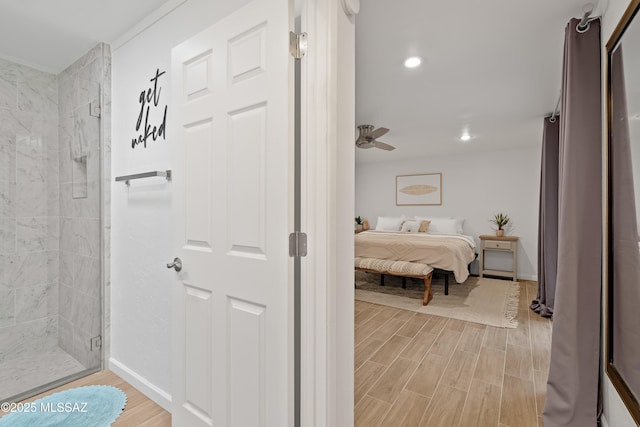 bathroom featuring baseboards, ensuite bathroom, a stall shower, and wood tiled floor