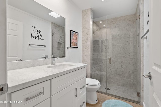 full bathroom with toilet, a stall shower, vanity, and wood finished floors