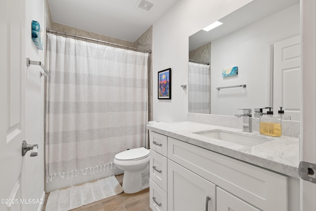 full bath with wood finish floors, visible vents, toilet, curtained shower, and vanity