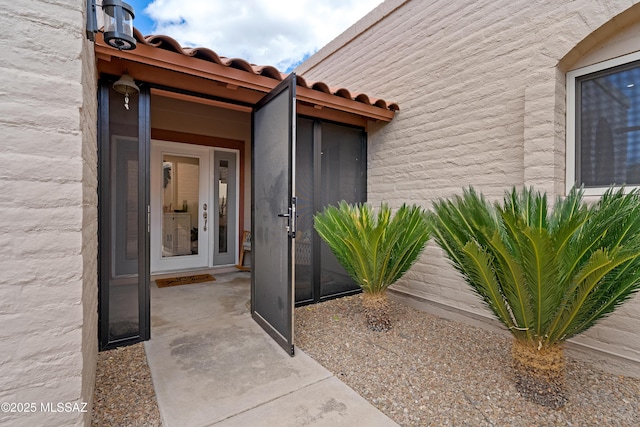 property entrance featuring a tile roof