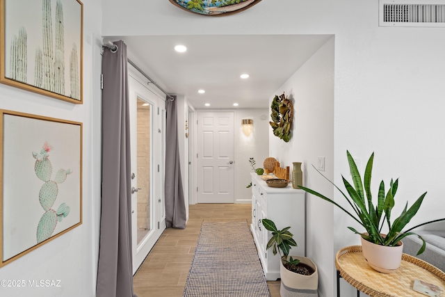 hall with recessed lighting, visible vents, and light wood finished floors