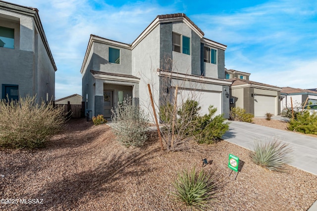 view of front facade featuring driveway, an attached garage, and stucco siding