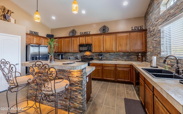 kitchen with brown cabinets, black appliances, light countertops, and a sink