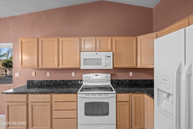 kitchen featuring white appliances, dark stone countertops, and light brown cabinetry