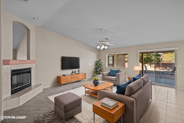 living area featuring ceiling fan, lofted ceiling, a fireplace, and tile patterned floors