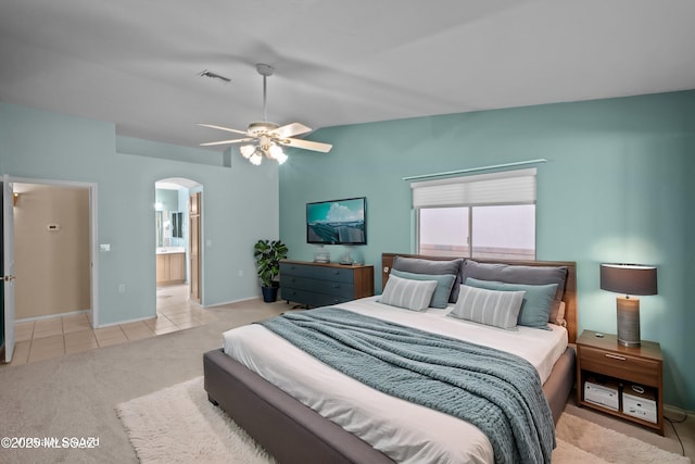 bedroom with arched walkways, carpet, lofted ceiling, visible vents, and tile patterned floors