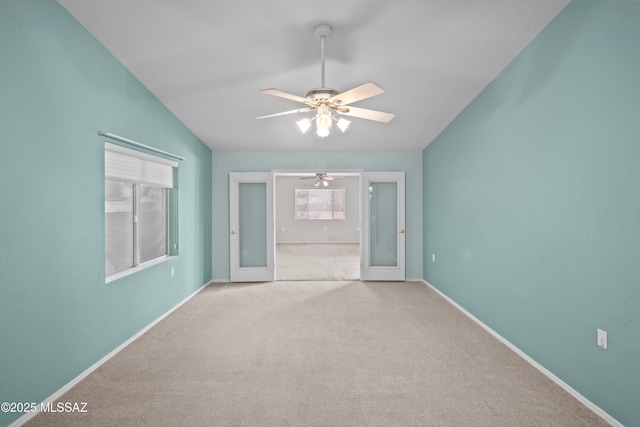 unfurnished room featuring carpet floors, french doors, a ceiling fan, vaulted ceiling, and baseboards