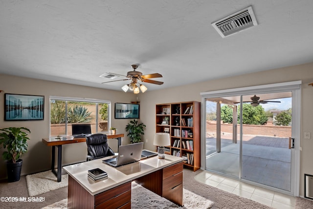 office space with ceiling fan, a wealth of natural light, and visible vents