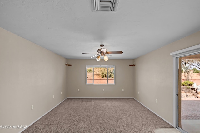 spare room featuring a ceiling fan, baseboards, visible vents, and carpet flooring