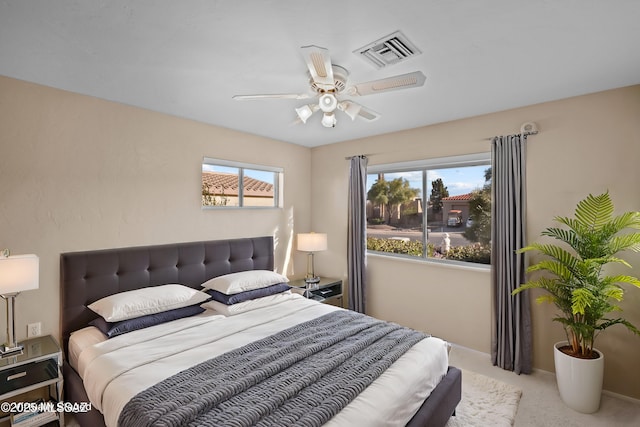 carpeted bedroom featuring visible vents and a ceiling fan