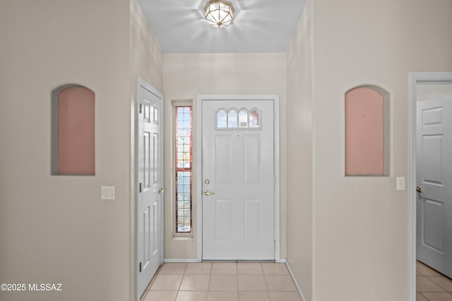 foyer entrance featuring baseboards and light tile patterned flooring