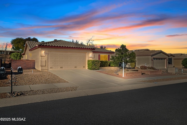 view of front of property featuring a garage, fence, a tile roof, driveway, and stucco siding