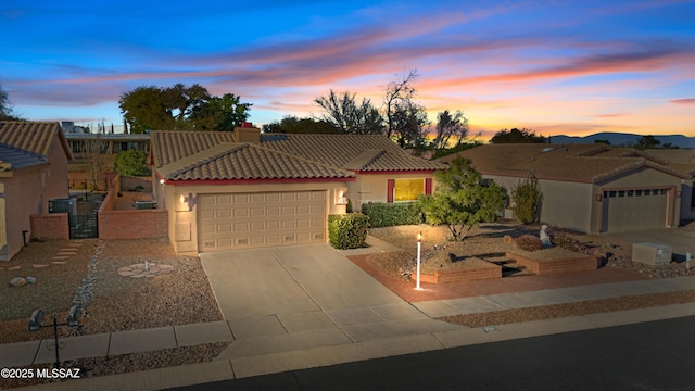 view of front of property with a garage, stucco siding, driveway, and a tiled roof