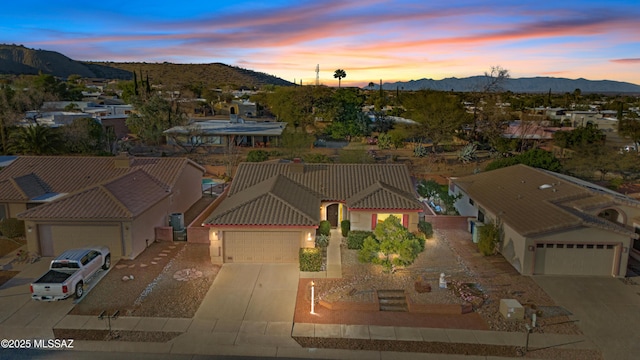 aerial view at dusk featuring a mountain view