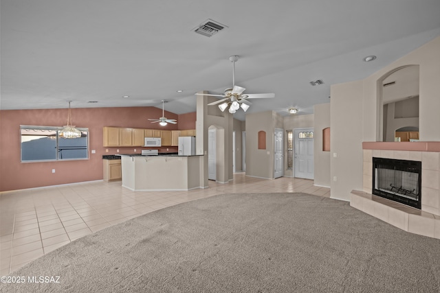 unfurnished living room featuring light tile patterned floors, a tiled fireplace, visible vents, and light colored carpet