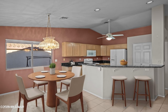 kitchen featuring white appliances, visible vents, a kitchen breakfast bar, a ceiling fan, and light brown cabinetry