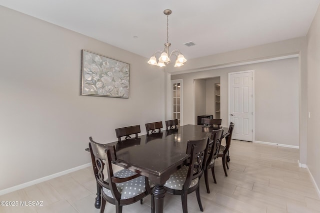 dining space featuring a notable chandelier, visible vents, and baseboards