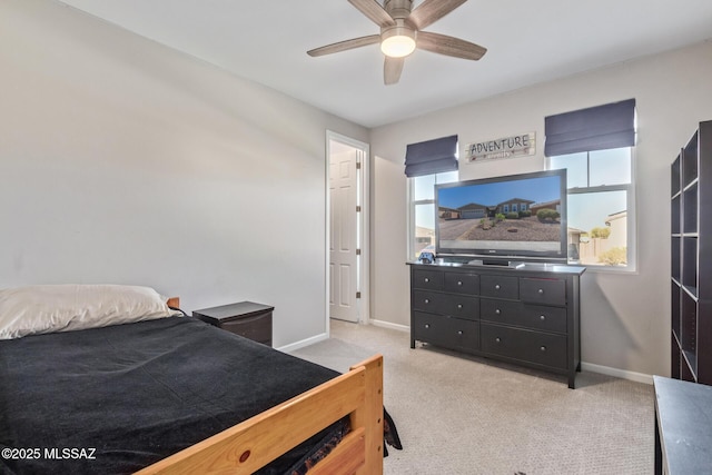 bedroom featuring a ceiling fan, light colored carpet, and baseboards