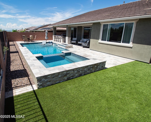 view of pool with a patio area, a yard, a pool with connected hot tub, and a fenced backyard