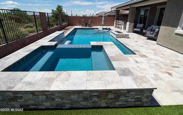 view of swimming pool with outdoor dining space, a fenced backyard, a pool with connected hot tub, a patio area, and outdoor dry bar