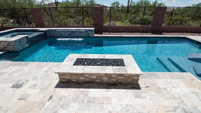 view of pool with a patio area, a pool with connected hot tub, and fence