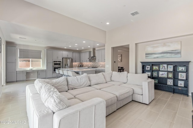 living area featuring light tile patterned flooring, recessed lighting, and visible vents