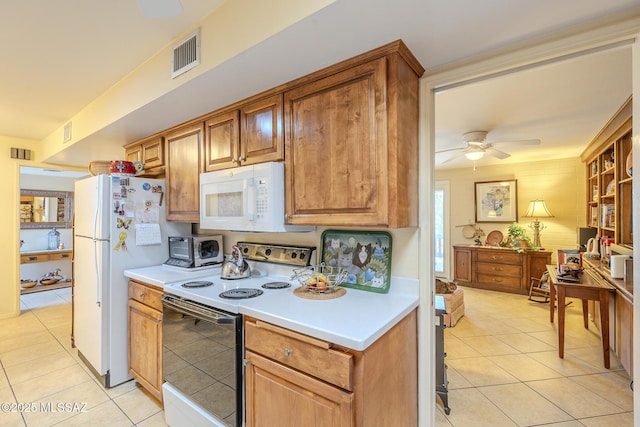 kitchen with light tile patterned floors, light countertops, white appliances, and visible vents