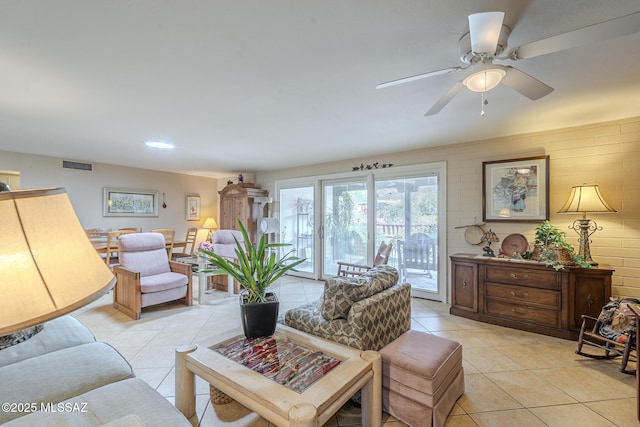 living room with light tile patterned floors, visible vents, and a ceiling fan